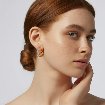 A model wearing the sparkling 18k gold plated Aura Teardrop Stud Earrings to showcase their statement size.