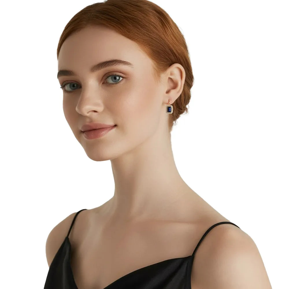 Close-up view of the blue emerald-cut zirconia earring on a model