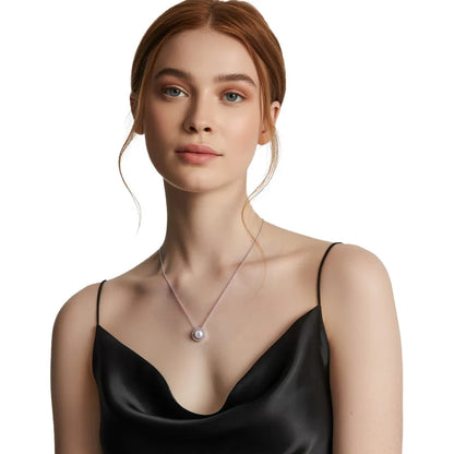 Close-up of a woman wearing a silver pearl necklace with a sparkling halo setting