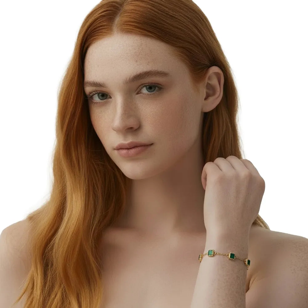 Redhead model wearing a delicate 14K gold emerald green square station bracelet.