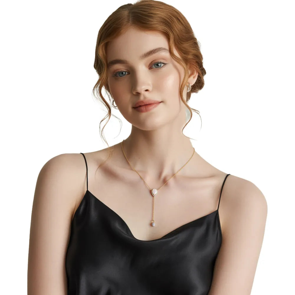 Model wearing elegant gold Y-necklace with pink rose quartz stone and black evening dress.