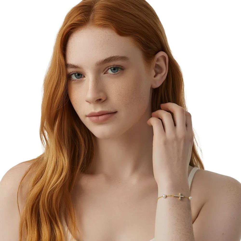 Model showcasing the elegant gold sideways cross bracelet with pearl details.
