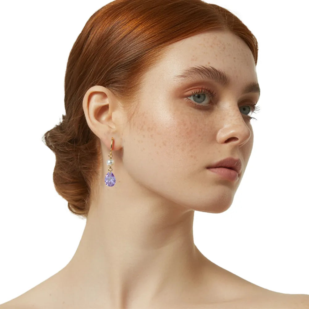 Close-up of redhead model wearing elegant lavender and pearl drop earrings.