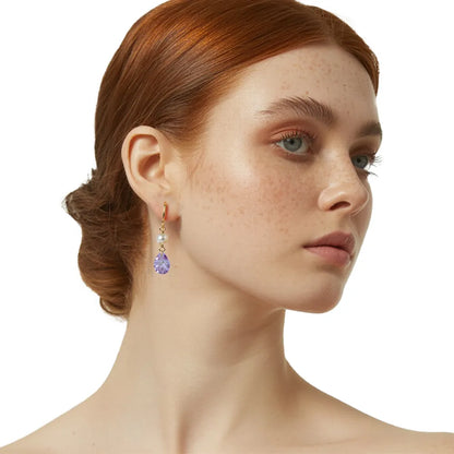 Close-up of redhead model wearing elegant lavender and pearl drop earrings.