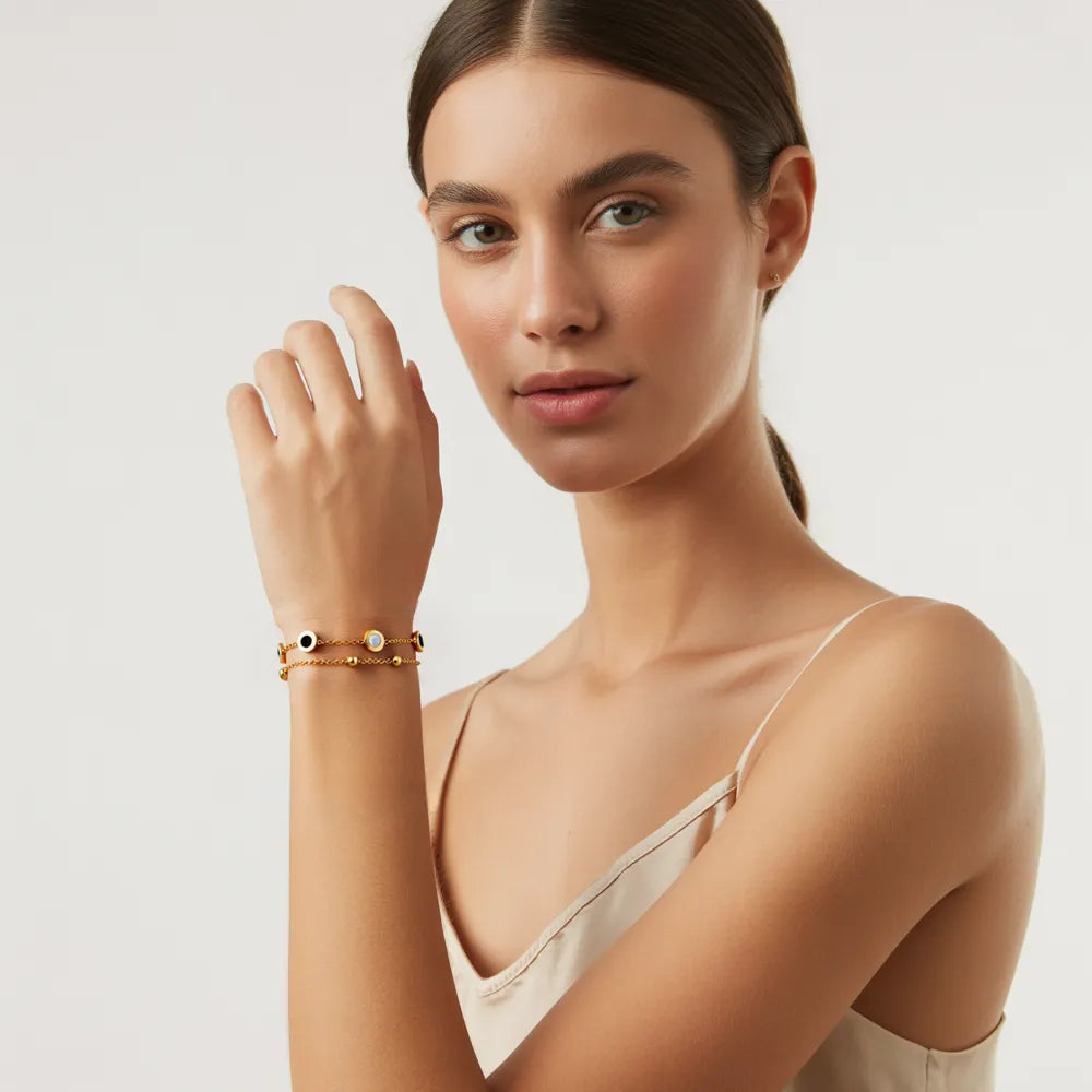Model wearing the 18K gold Roman Station Layered Bracelet, showing its fit on the wrist.