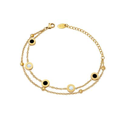 18K gold plated layered bracelet with mother of pearl and black onyx station charms on a white background