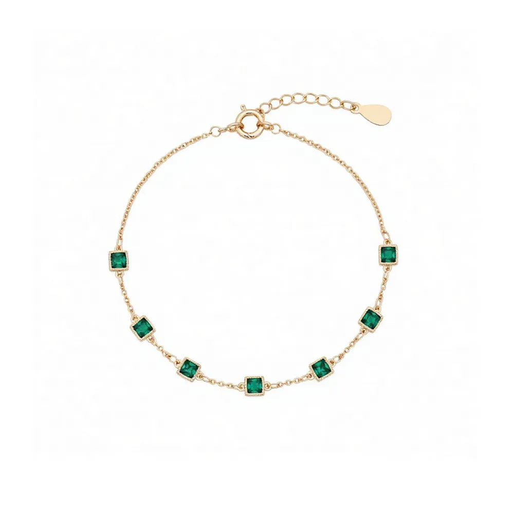 S925 sterling silver bracelet plated in 14K gold, featuring station-set emerald green square zircons on a white background.