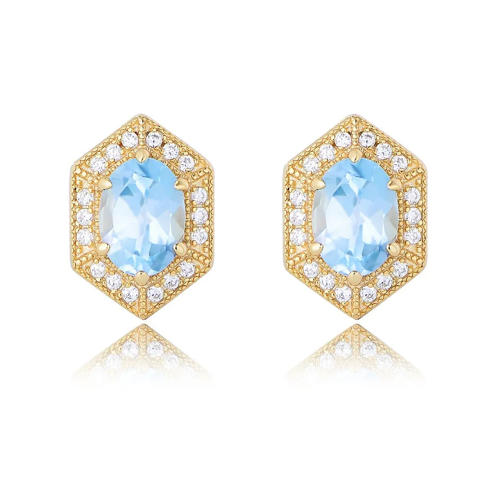 Front view of S925 sterling silver hexagon stud earrings featuring an oval-cut natural Blue Topaz gemstone and vintage gold detailing on a white background