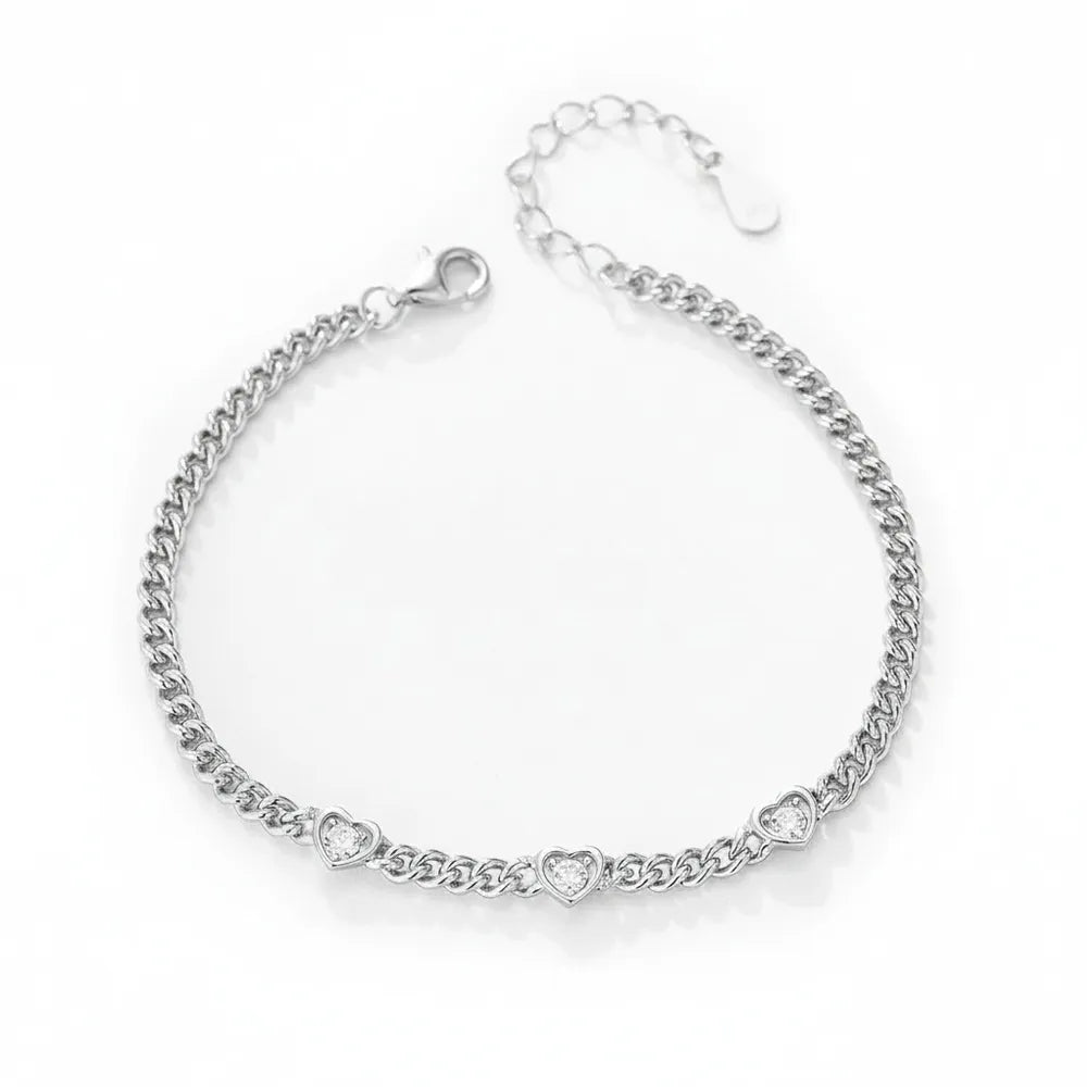 S925 sterling silver curb chain bracelet featuring three bezel-set heart zircons on a white background.