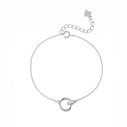 Studio shot of a minimalist S925 sterling silver bracelet with two intertwined circles—one polished and one encrusted with cubic zirconia