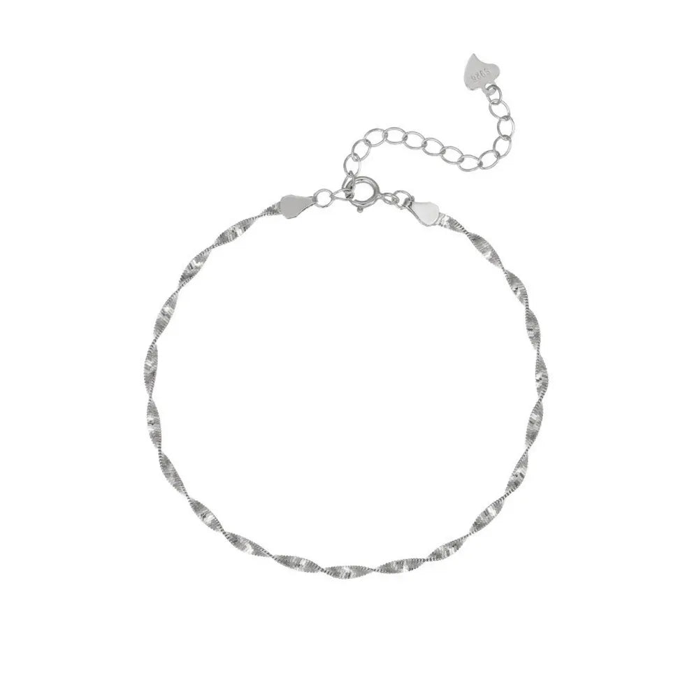 Studio shot of a high-polished S925 sterling silver minimalist water wave bracelet with a tiny heart charm at the end, isolated on white