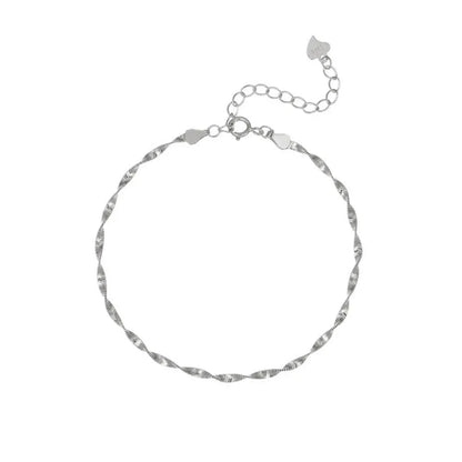 Studio shot of a high-polished S925 sterling silver minimalist water wave bracelet with a tiny heart charm at the end, isolated on white