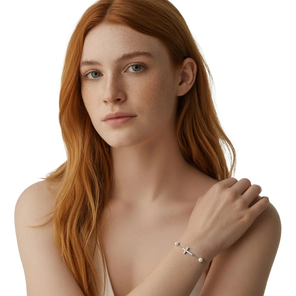 Close-up of redhead model wearing the silver sideways cross and pearl bracelet.
