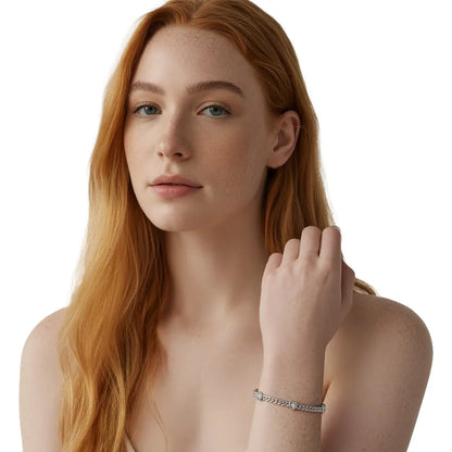 Close-up of woman wearing a silver heart zircon bracelet, showing the classic curb chain design.