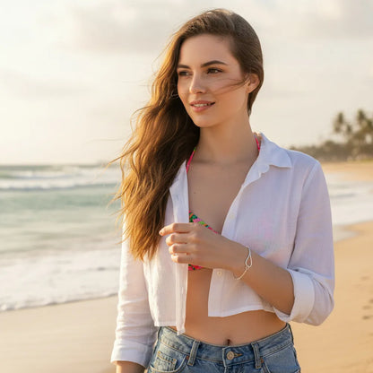 Model styling the bold yet minimalist silver knot bracelet with summer resort wear by the sea, perfect for a chic vacation ensemble.