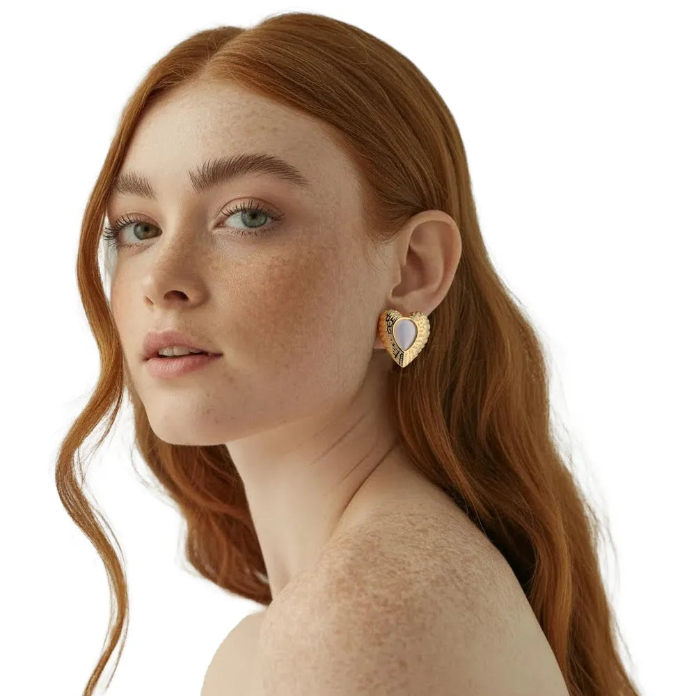 Model showing the large 18K gold white cat eye heart stud earring worn on the ear, demonstrating the statement size and retro look