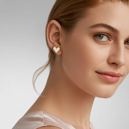 Model showcasing elegant white shell heart earrings with durable 18K gold PVD plating.
