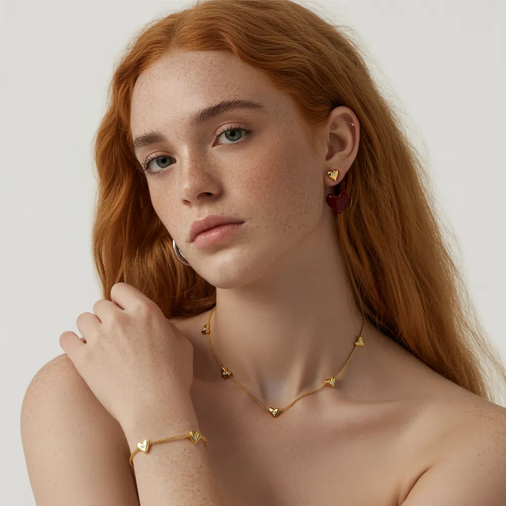 Model wearing the complete Amara Solitaire Heart set, including the station necklace, bracelet, and stud earrings